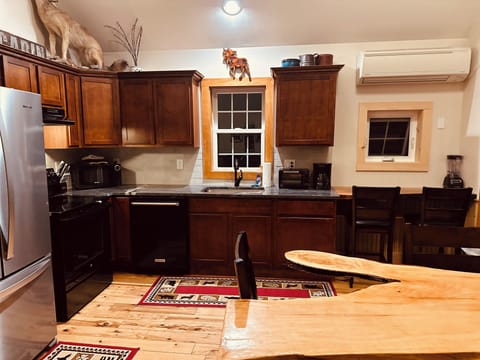 Kitchen with modern appliances and breakfast bar nook with picture window.

