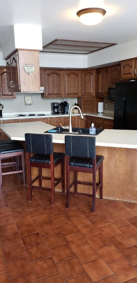 Kitchen with some island seating.  Toaster and 2 coffee pots (Kerig and Reg).