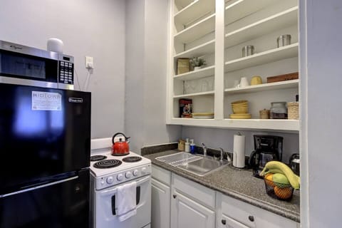 As you step into the compact kitchen, the vibe welcomes you with its clean, organized shelves and essentials like a coffee maker, ready to fuel your mornings.