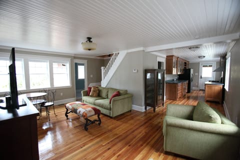 living area with couch, chair, ottoman, card table, television