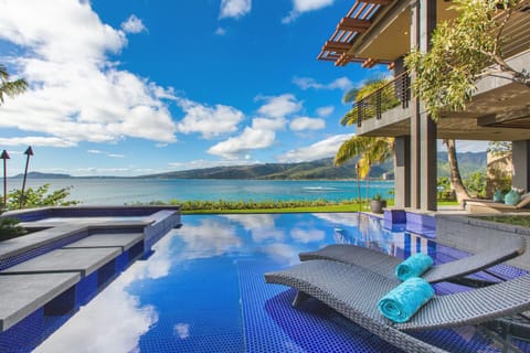 Infinity-edge pool with chaise lounges, where guests can soak up the sun and watch the ocean merge with the horizon.