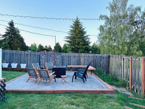 Outdoor fire-pit area with 6 comfortable chairs & bench.   Landscape lighting.