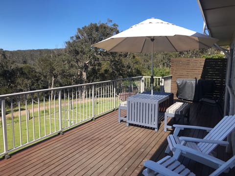 Alfresco dining on the deck overlooking bush and ocean