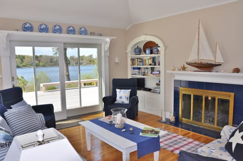 Open and airy gathering space with lake views, cozy fireplace, access to deck.