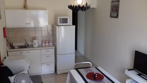 Kitchenette with all necessities for cooking, indoor dining and drinking.