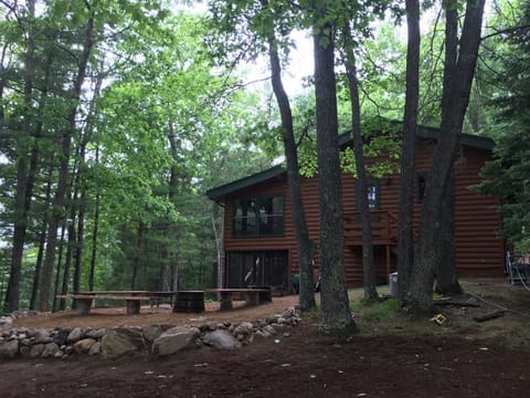 Newly upgraded fire pit area and recently stained half-log cabin.