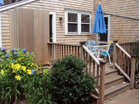 Deck with table, umbrella and Telescope chairs.  Outdoor shower on left.