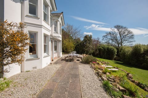 The sun-trap area at the front of the house, with outdoor seating and sunbeds
