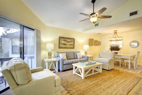 Living And Dining Room With Screened Porch Access - The main living area connects the sofa, dining table, and screened porch in one bright second-floor layout.