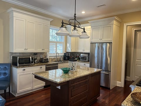 Kitchen w/ white cabinets, island, high-end  appliances and granite counter tops