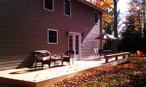 Back deck with sitting area, outdoor table, and bench seating