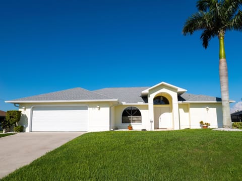Bright, spacious home with lush green lawn and palm tree