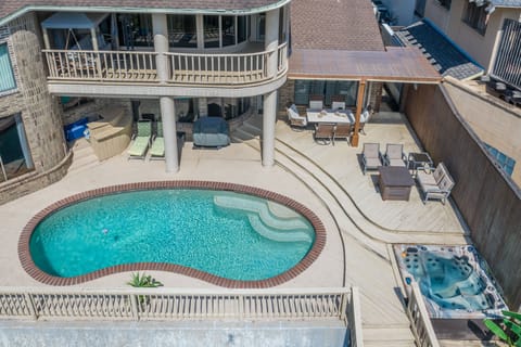 Ariel of pool, hot tub, and master balcony on second story