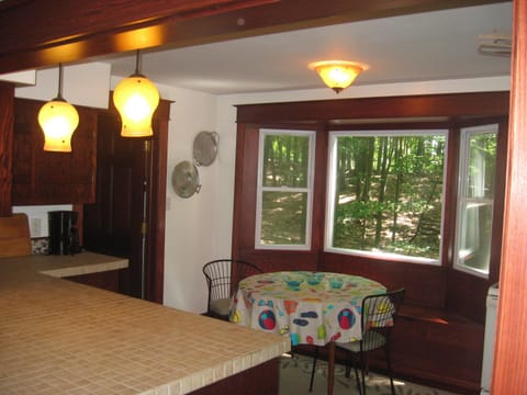 Open Kitchen with eat in area table with bench and 2 chairs and bar w/ 3 stools