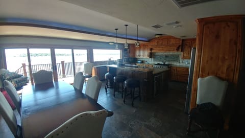 View of open kitchen and dining area looking out to lake. 