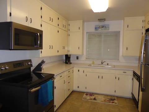 Large and bright kitchen fully stocked with pots/pans and dishes. 