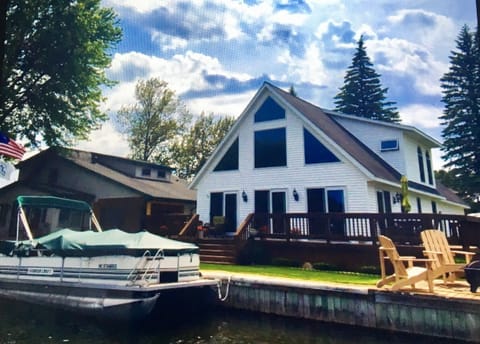 Front of house, wrap around deck with abundant seating and fire pit facing lake.