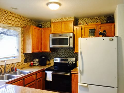 Full Kitchen with pots, pans, plates and utensils.