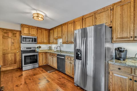 Kitchen includes stainless steel appliances, wood cabinets and granite counters.