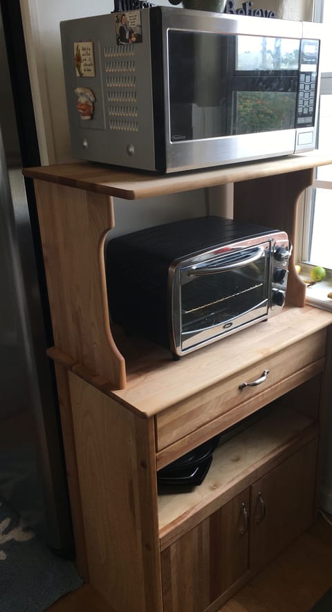Kitchen cabinet with microwave and toaster oven.