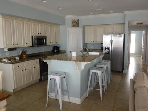 Well stocked kitchen with bar seating for four adjacent to family room.