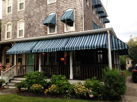 Front view looking at the condo and porch on ground floor w/ awnings