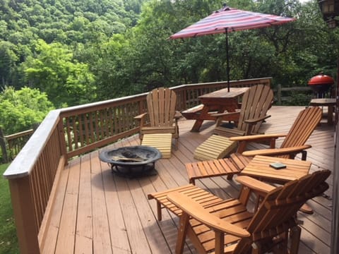 Deck w fire pit, chairs, picnic table and grill.