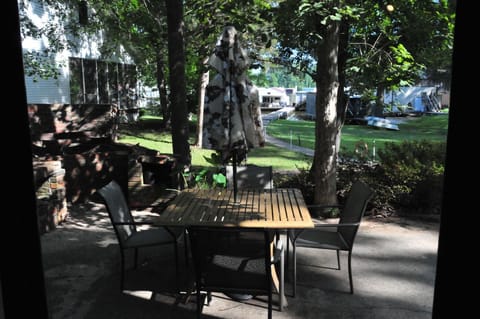 Large patio with table, umbrella, 4 dining chairs, 4 adirondack chairs.