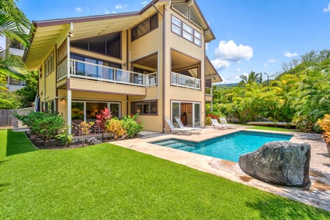 Back view of home with yard and pool