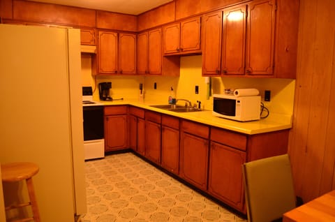Kitchen is stocked with pots, pans, utensils, and dishes.