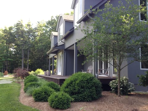 Front porch get beautiful morning sun and is outfitted with chairs and table.
