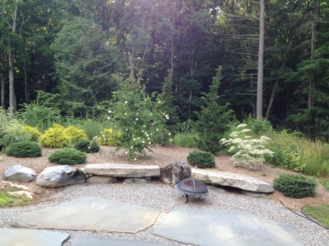 Back patio has Adirondack chairs, fire pit and a Weber grill.