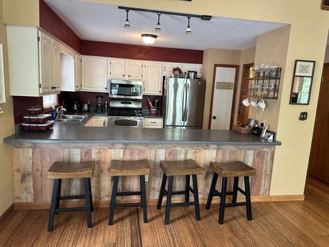 Kitchen bar open to dining room and living room. Second refrigerator in Basement
