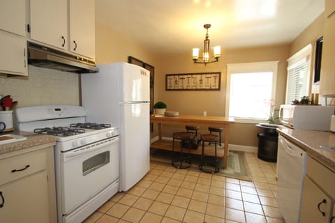 Kitchen with eat-in butcher block and fridge with icemaker & gas stove.