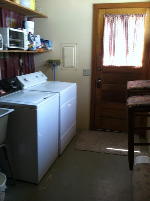 Laundry room with laundry sink, washer and dryer for guest use.