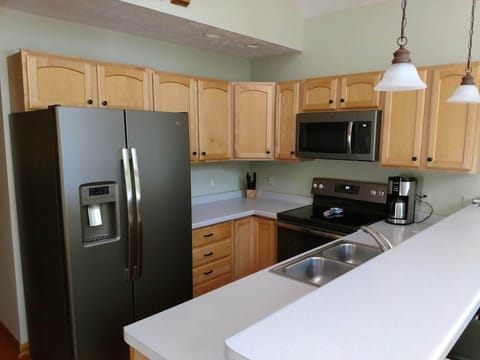 Full kitchen - dishwasher, stove, fridge with ice and water, cookware, dishes.