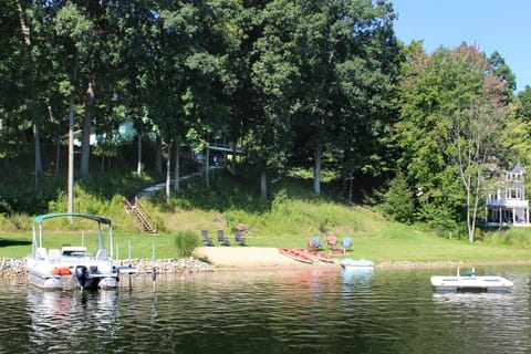 Sitting on a shady perch, the house overlooks a beach, yard, dock and raft.