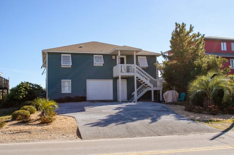 Street side with large paved drive way.  Patio with gas grill on the right.