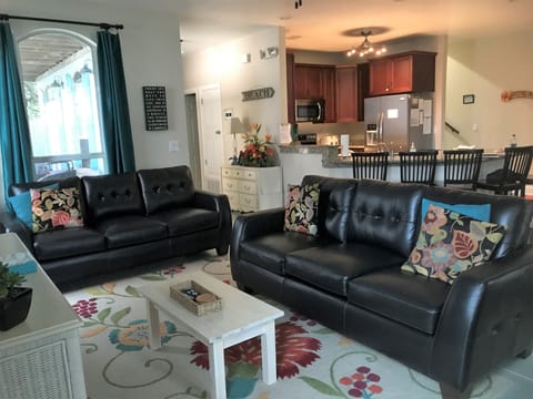 Family room with leather couches, smart tv and blu ray player.