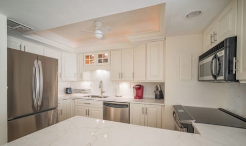 Kitchen update features quartz countertops and modern backsplash.