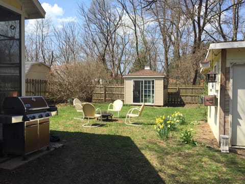 Large fenced in yard with gas grill and studio cottage.