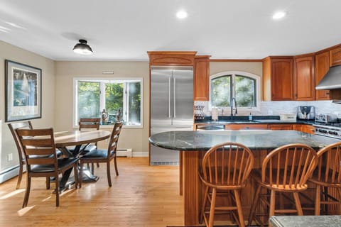 Breakfast table and large modern refrigerator. 