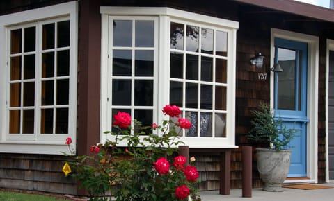 Cozy Nantucket style cottage with shingle siding, bay window and dutch doors.