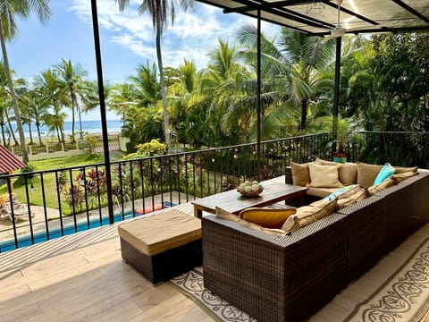 Relax on the covered, ocean-view balcony with blush seating and fans overhead
