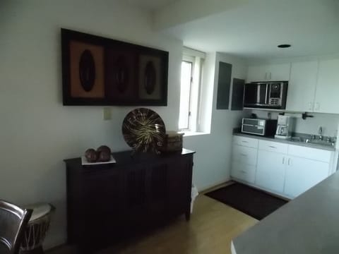 Kitchen area with refrigerator, toaster oven, microwave and coffee maker