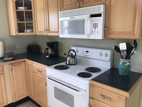 Kitchen is fully stocked with dishes, glassware, and cooking equipment.
