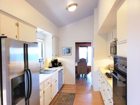 Inside kitchen looking out to dining and ocean view sliding glass doors, windows