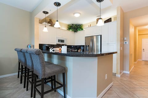 Modern kitchen with new appliances and dining counter.