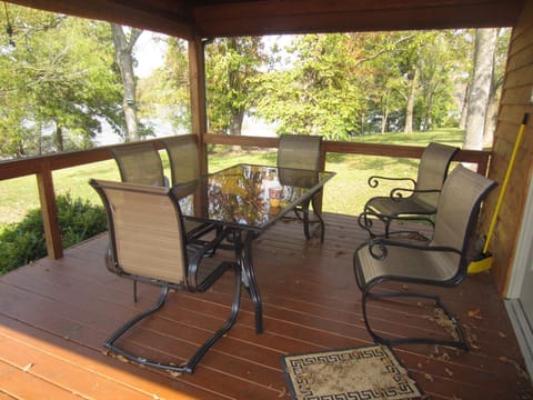 The covered deck area/ table with the beautiful lake view behind it.