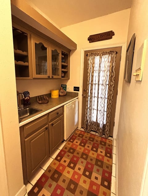 Upstairs wet bar in hallway leading out onto the upper-level outdoor deck